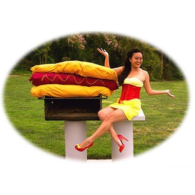 Competitive eater, Mary Bowers models her larger than life appetite with a hotdog big enough for the whole party